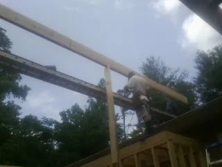 Carpenter setting a ridge beam over a new addition frame — Ice Dam Removal by Roofing Brothers in Rowena