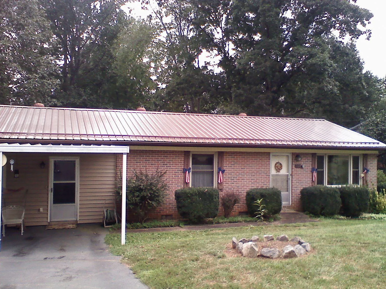 Bronze metal roof and carport on a brick ranch home — Roof Repair work by our crew in Rowena